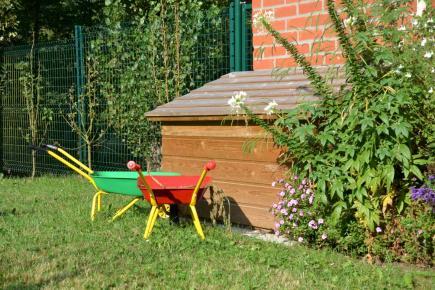 2 brouettes dans jardin devant niche